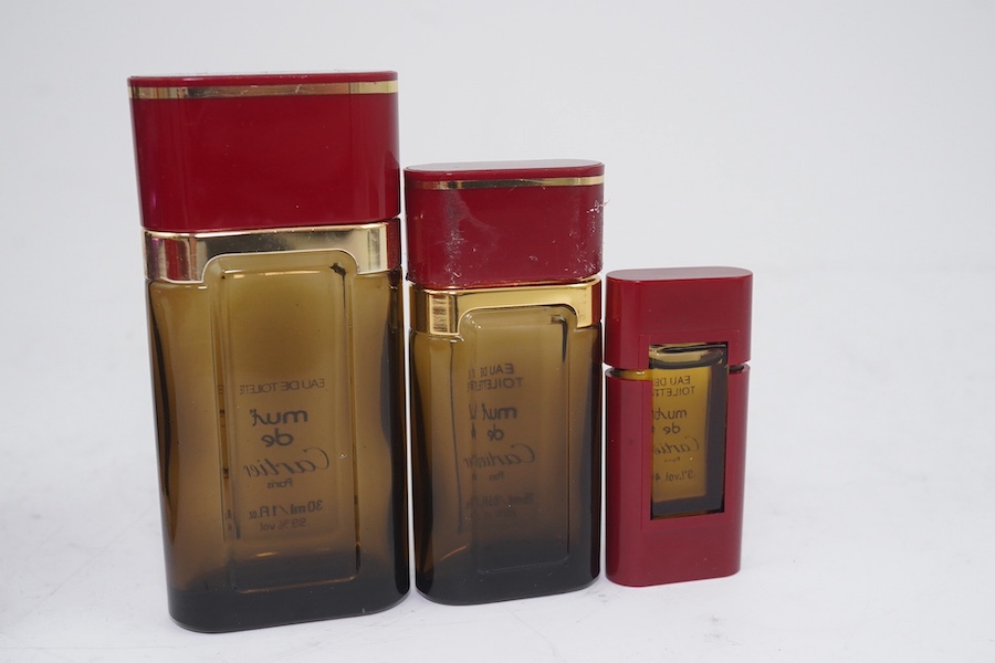 An assortment of Must de Cartier bordeaux leather accessories